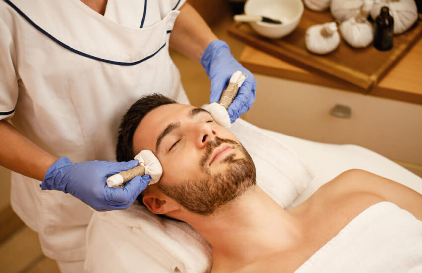 relaxed-man-having-thai-herbal-head-massage-wellness-center