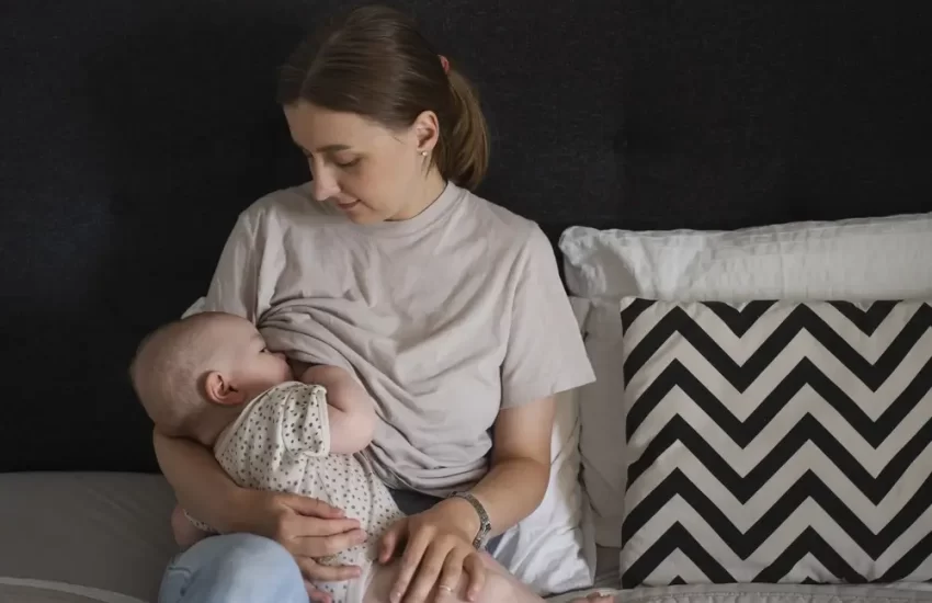 medium-shot-woman-breastfeeding-baby-bed